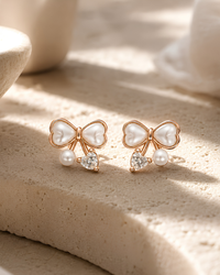 Close-up of Pearl Bow Stud Earrings showing the CZ heart accent